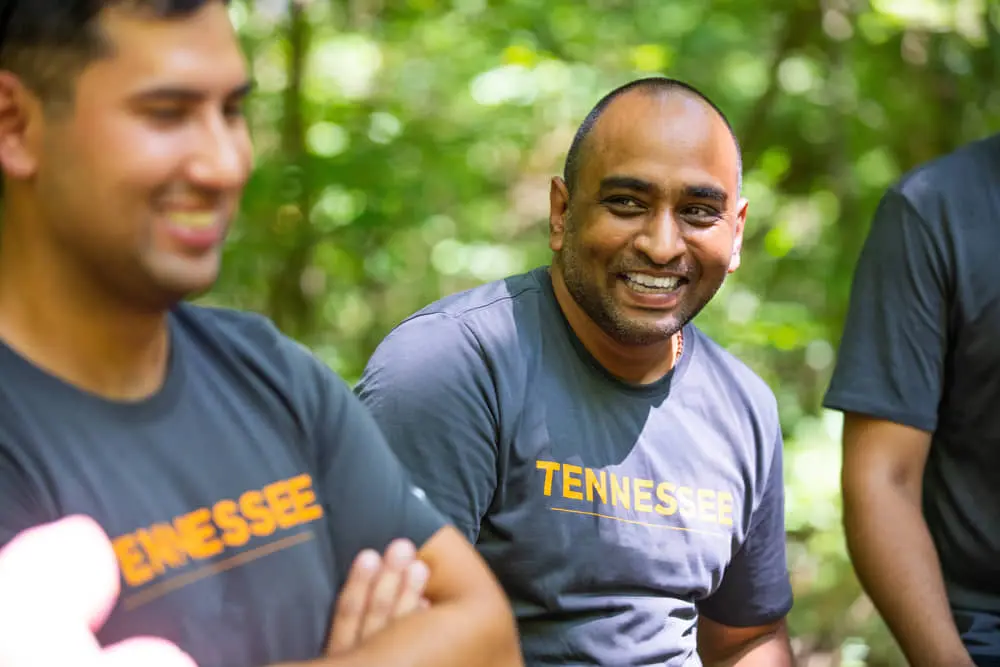 Man smiling outdoors with others