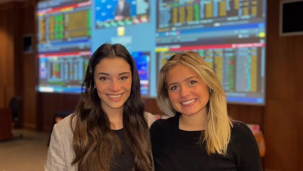 Jackie Tenney and Emily Becker smile in the Masters Investment Learning Center