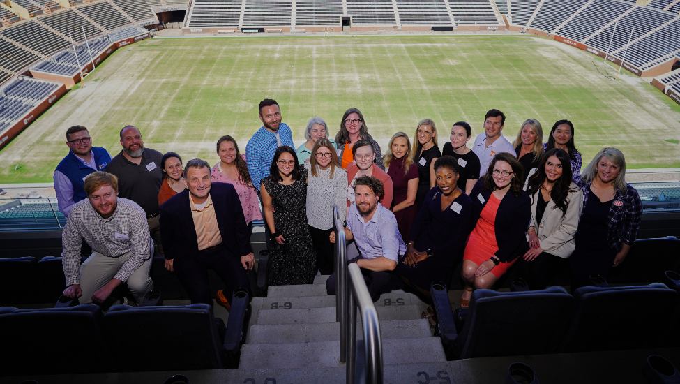 Winners of the 2023 Haslam College of Business Awards pose in Neyland Stadium with the football field behind them.