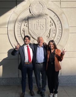 Julian Serrano, Ernie Cadotte and Kelley Hunt pose outside in front of the Fordham University sign