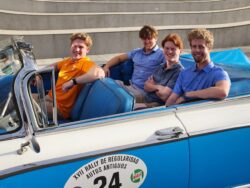 Students pose in one of the classic motor vehicles for which Cuba is known.