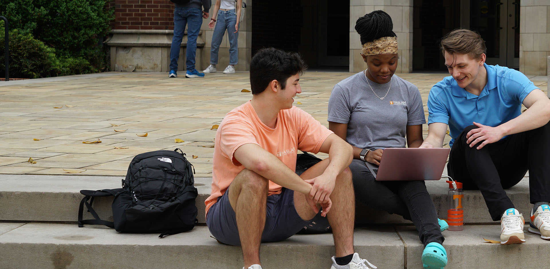 Students on a laptop outside of Haslam