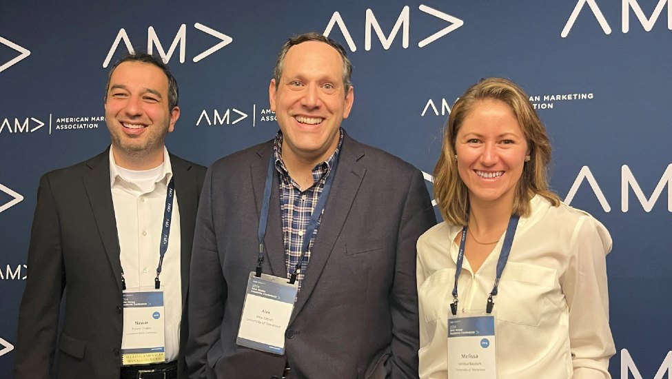Nawar Chaker, Alex Zablah, and Melissa Baucum pose in front of AMA branded backdrop
