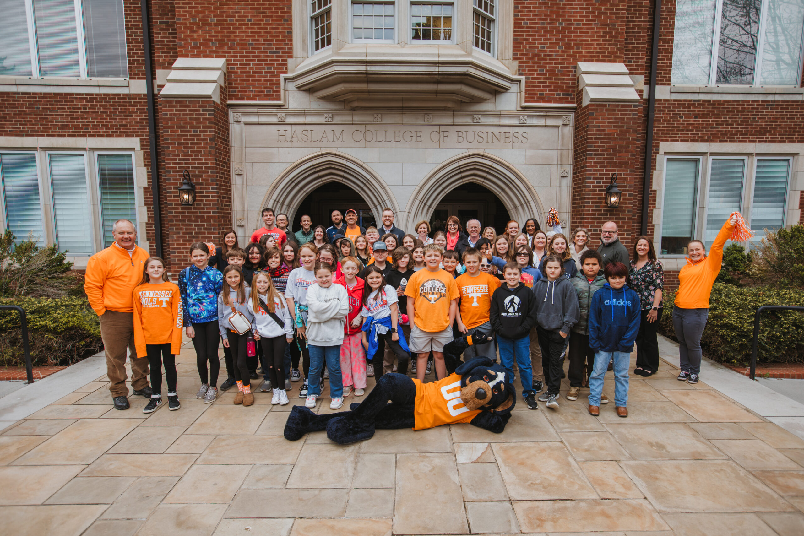 Young students in front of Haslam Business building with Smokey