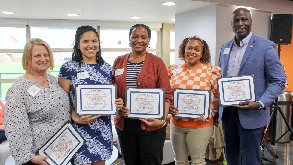 Members of the Haslam College of Business Office of Access and Community Connections pose and smile with their framed awards