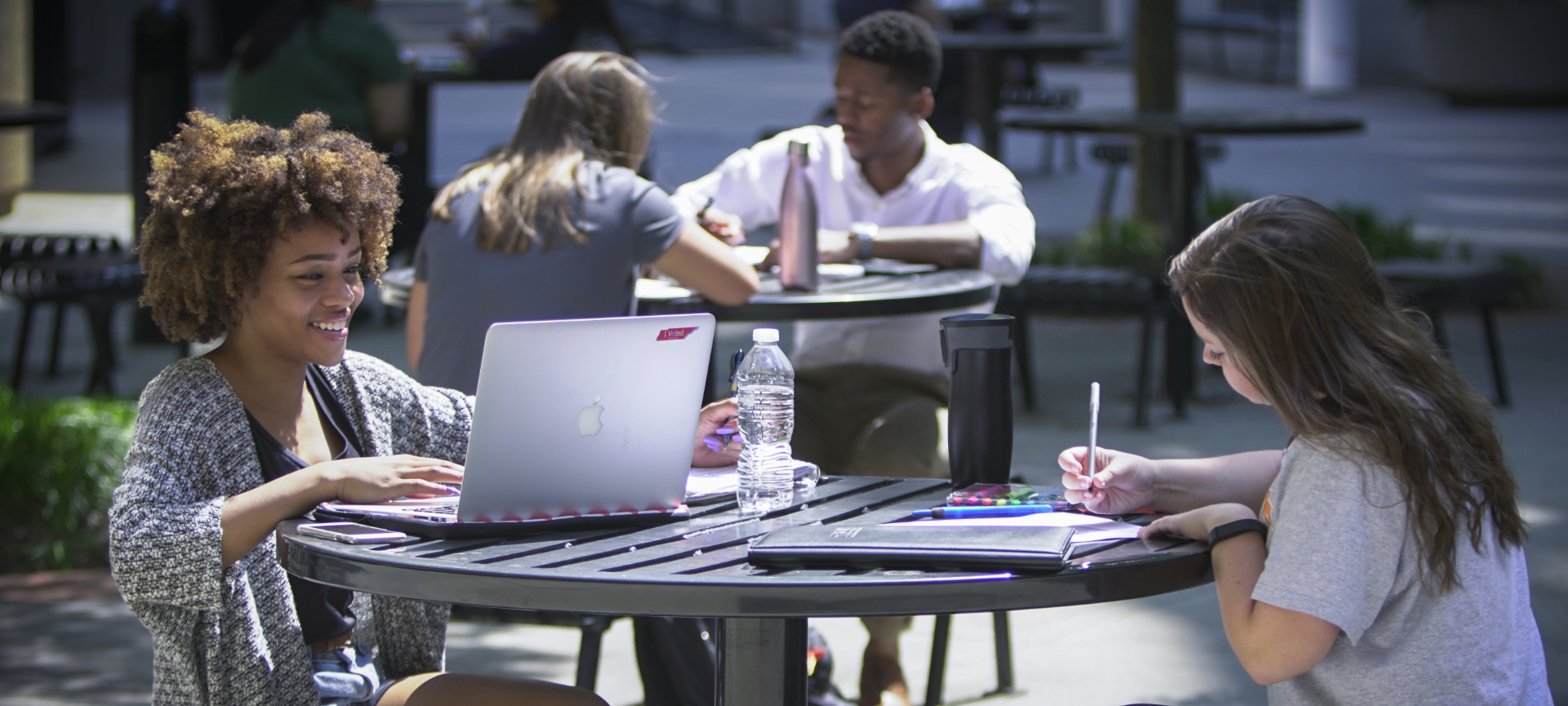 students studying outside at a table