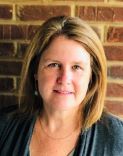 Portrait photo of Kelley Williams with brick wall in background