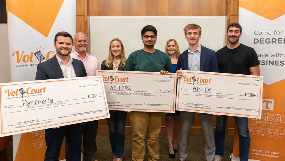 Vol Court winners pose with novelty checks and others involved in Vol Court fall 2024.