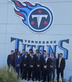 Some of the professional development trip participants pose in front of the Titans logo on the front of the headquarters. 