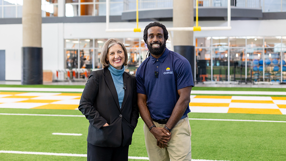 Derrick Furlow Jr. and Kim Quigley on the UT Volunteers football practice field.