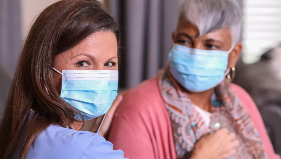 Home Healthcare Lady Wearing Blue Mask With An Eldery Lady Wearing a Blue Mask