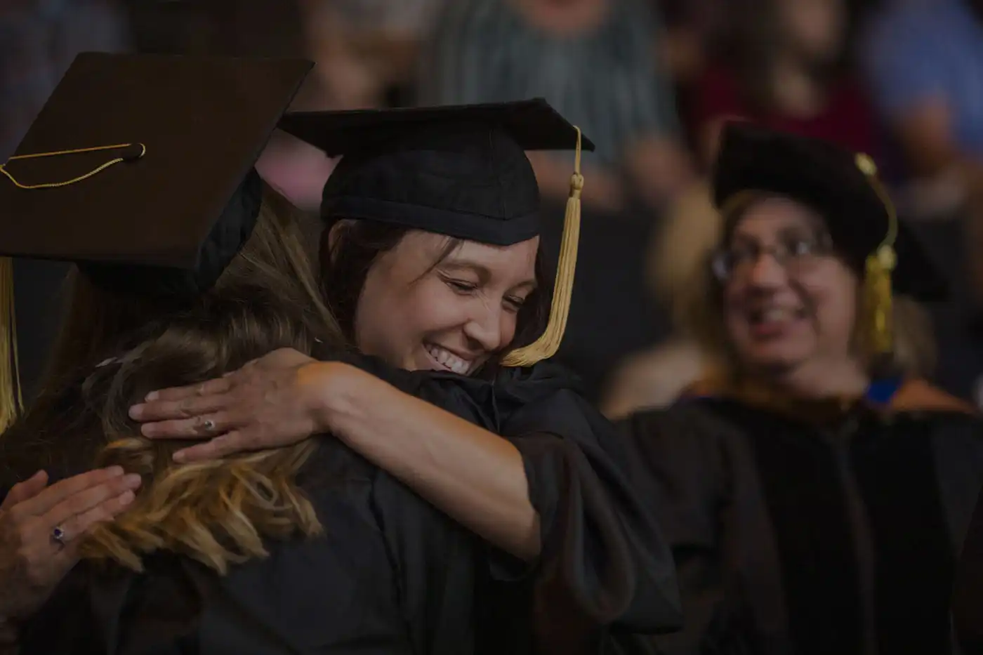 Graduates hugging at Graduation event