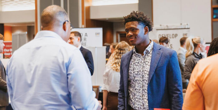 Two Men Speaking At Job Fair Event