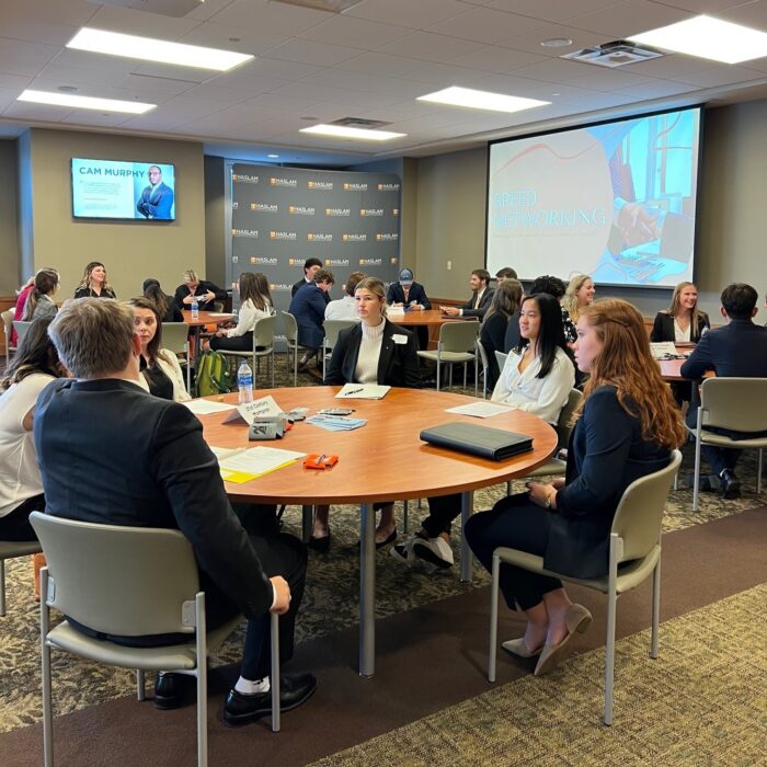 Students sitting at round tables at the Business Honors Discovery Experience