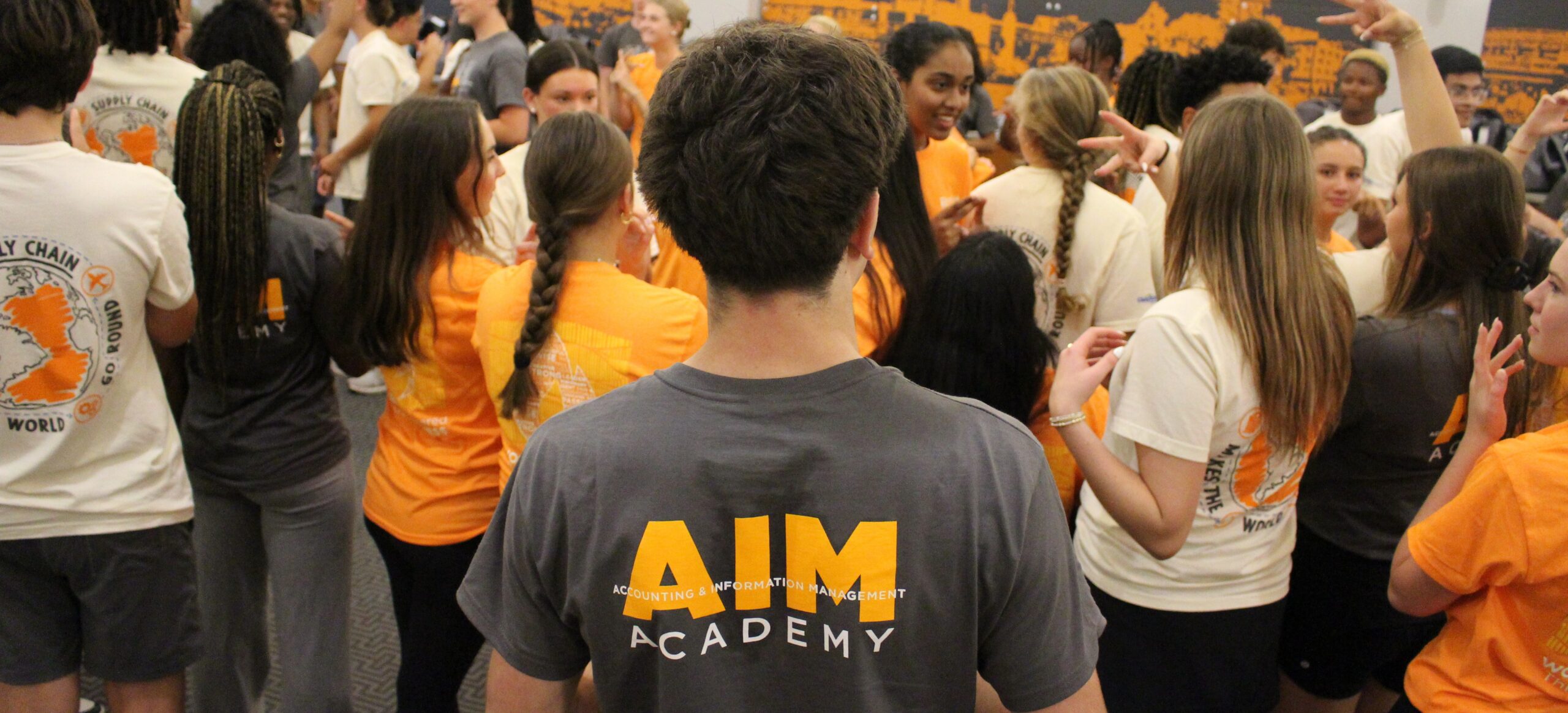 Student wearing an AIM Academy shirt during the summer program with large group of students