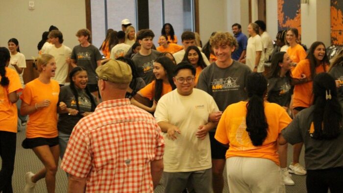 Participants from all three Haslam pre-collegiate programs - most dressed in shorts and program T-shirts - enjoy a teambuilding exercise.