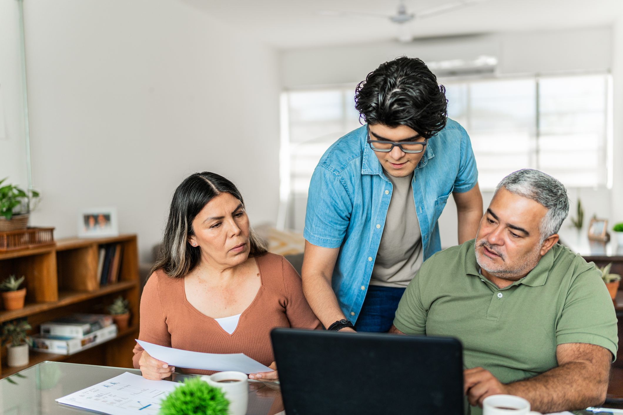 Family discussing higher education finances on laptop at home